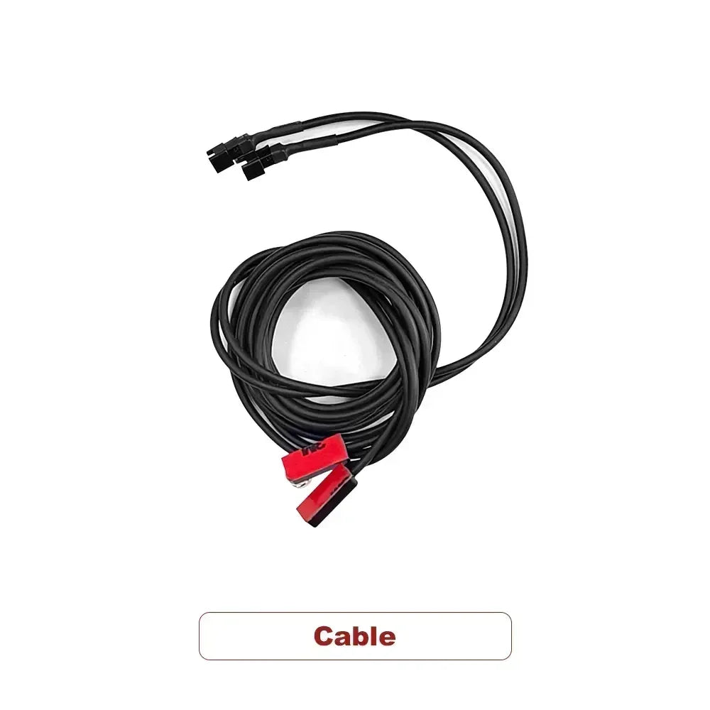 Black cable with two red connectors and dual black plugs coiled against white background